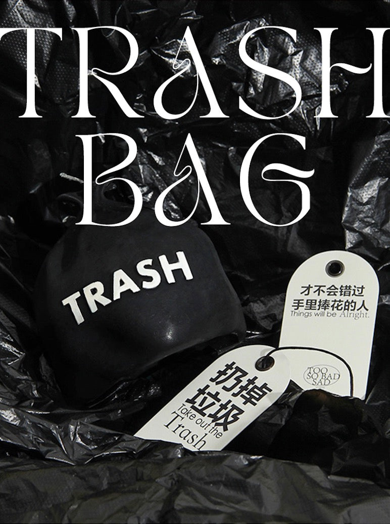 Black trash bag with 'trash' label and Chinese text on a dark background