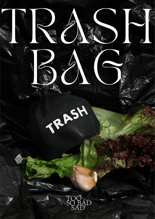 Black trash bag with text and food items on a black background