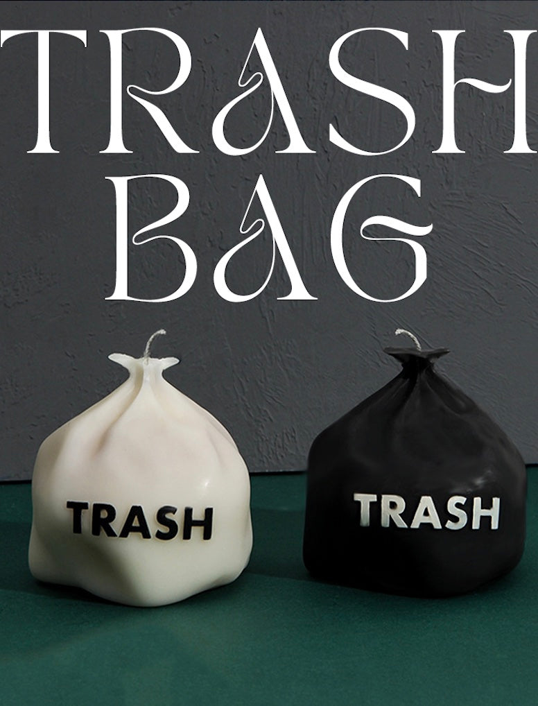White and black trash bags with 'TRASH' text on a dark background