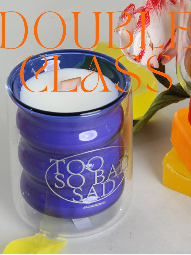 Blue candle jar with 'Too Bad Sad' text, surrounded by flowers and text overlay.
