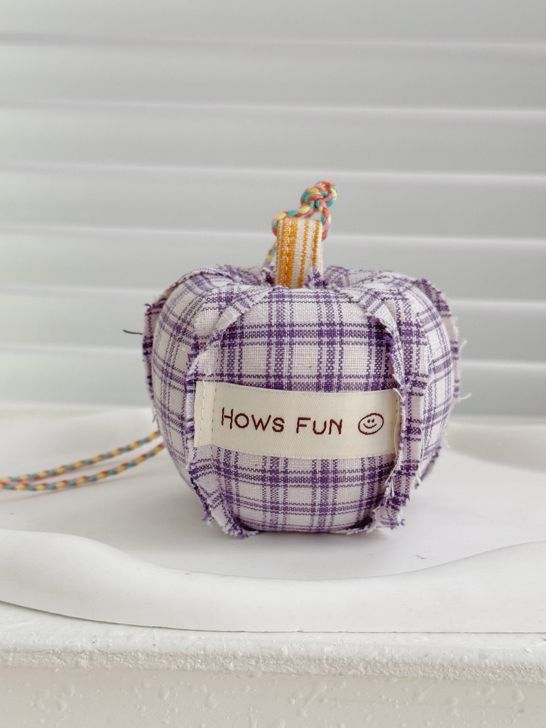 Plaid fabric pumpkin with 'Hows Fun' label on a white background
