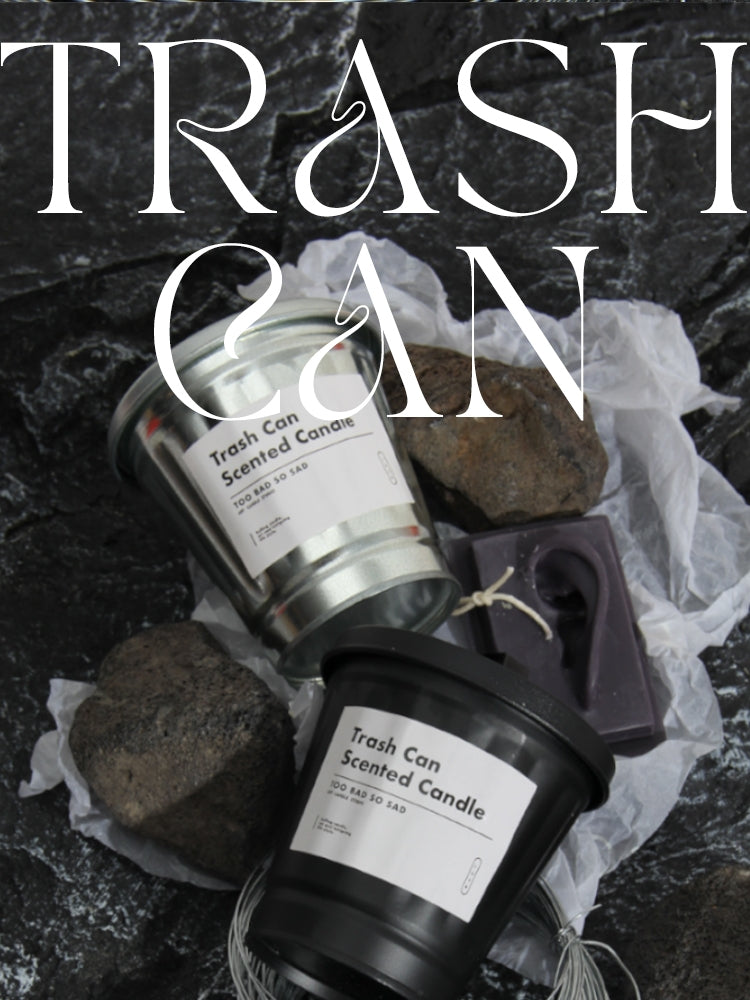 Trash can-scented candles with decorative elements on a dark background