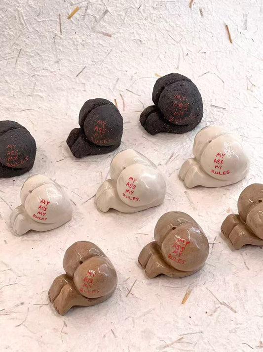 Collection of small ceramic figures with text on a textured white surface