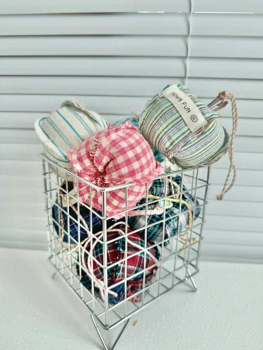 Basket with yarn and fabric items against a neutral background
