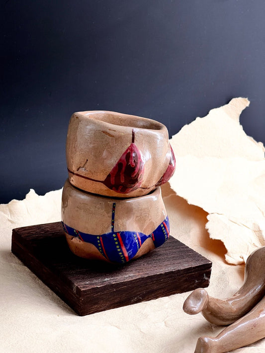 Two ceramic bowls stacked on a wooden block with a dark background