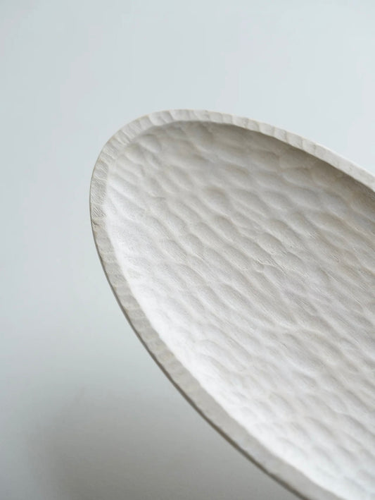 Close-up of a marble-patterned oval dish on a light gray background