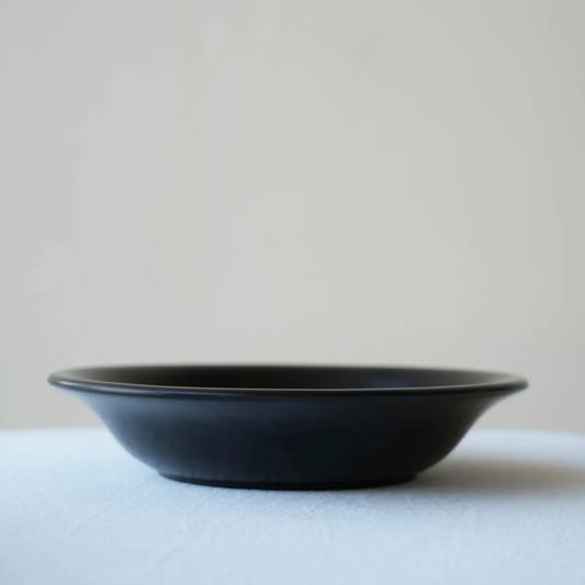 Black ceramic bowl on a light gray background