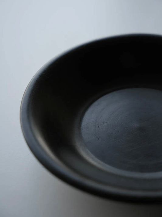 Black ceramic bowl on a light gray background