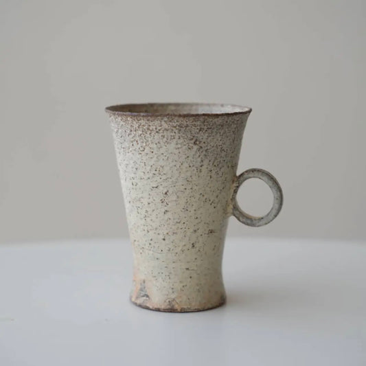 Speckled ceramic mug on a plain background