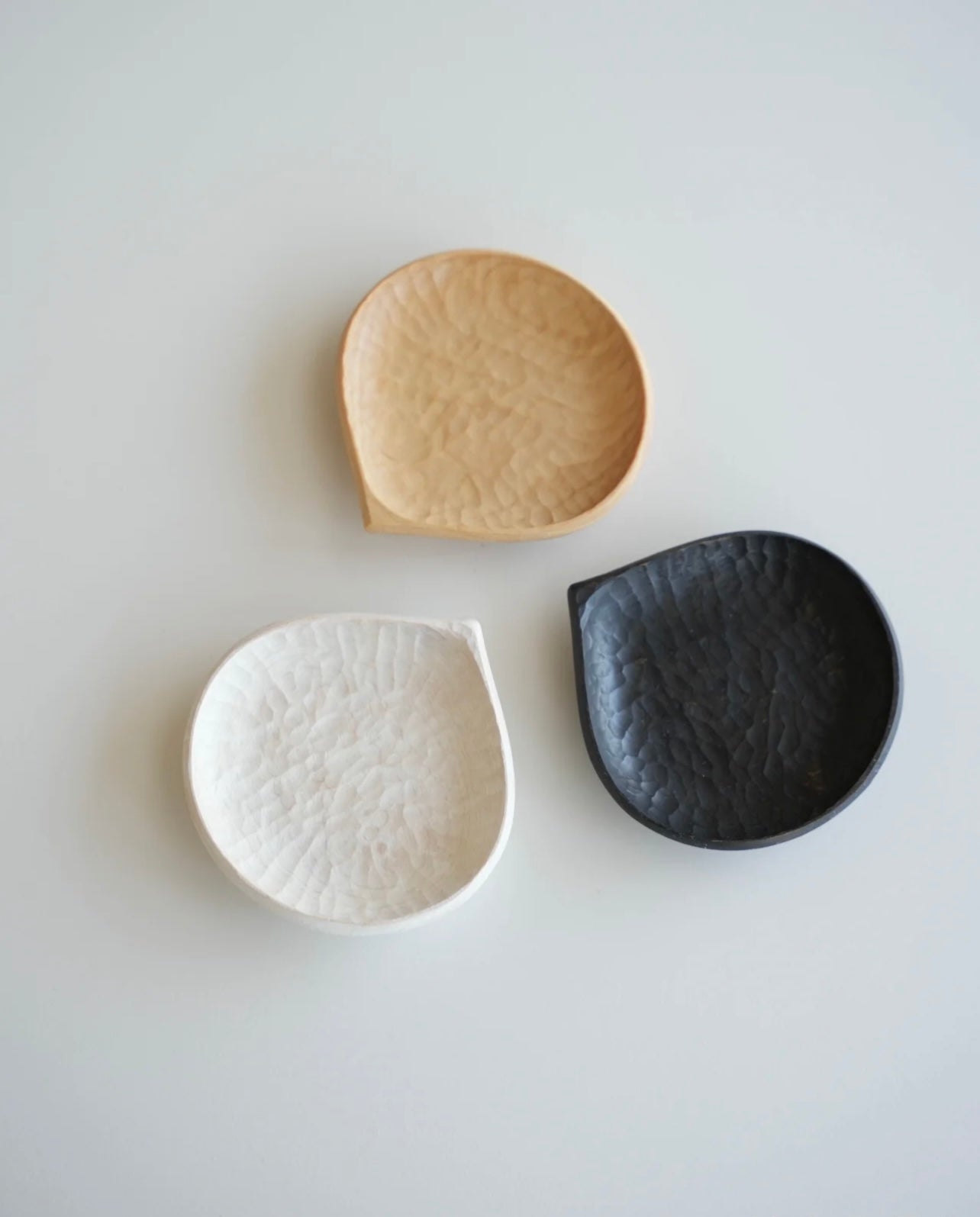 Three ceramic bowls in beige, white, and black on a light gray background with 'VAST' branding.