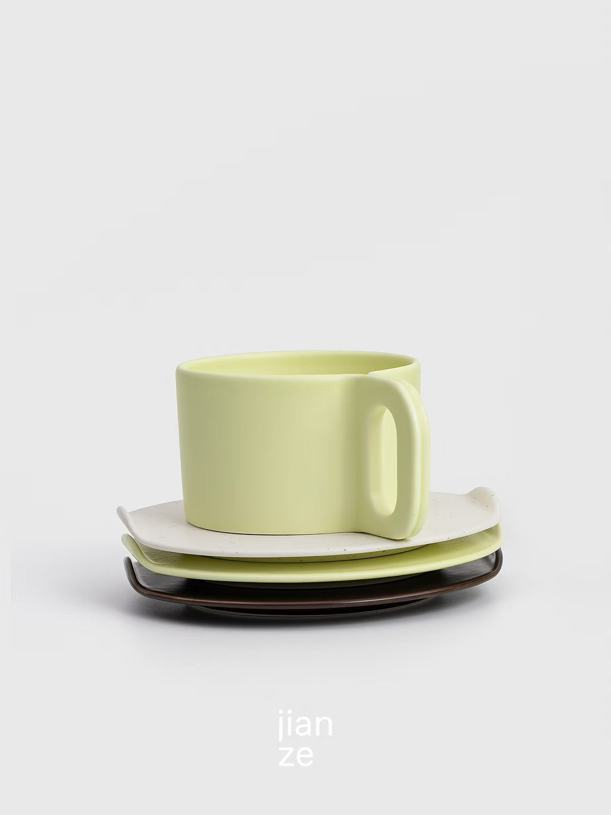 Green ceramic cup and saucer set on a light gray background with 'jian ze' branding.
