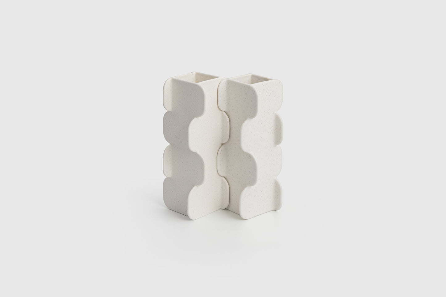 White ceramic vase with wavy pattern on a light gray background