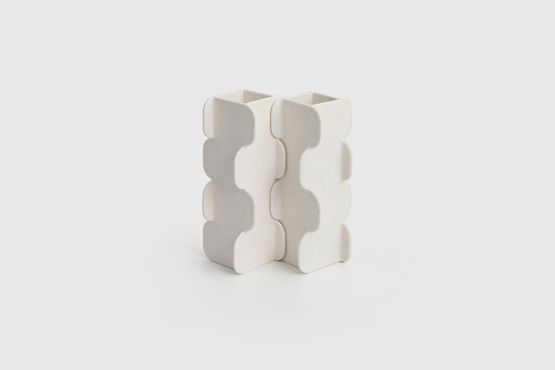 White ceramic vase with wavy pattern on a light gray background
