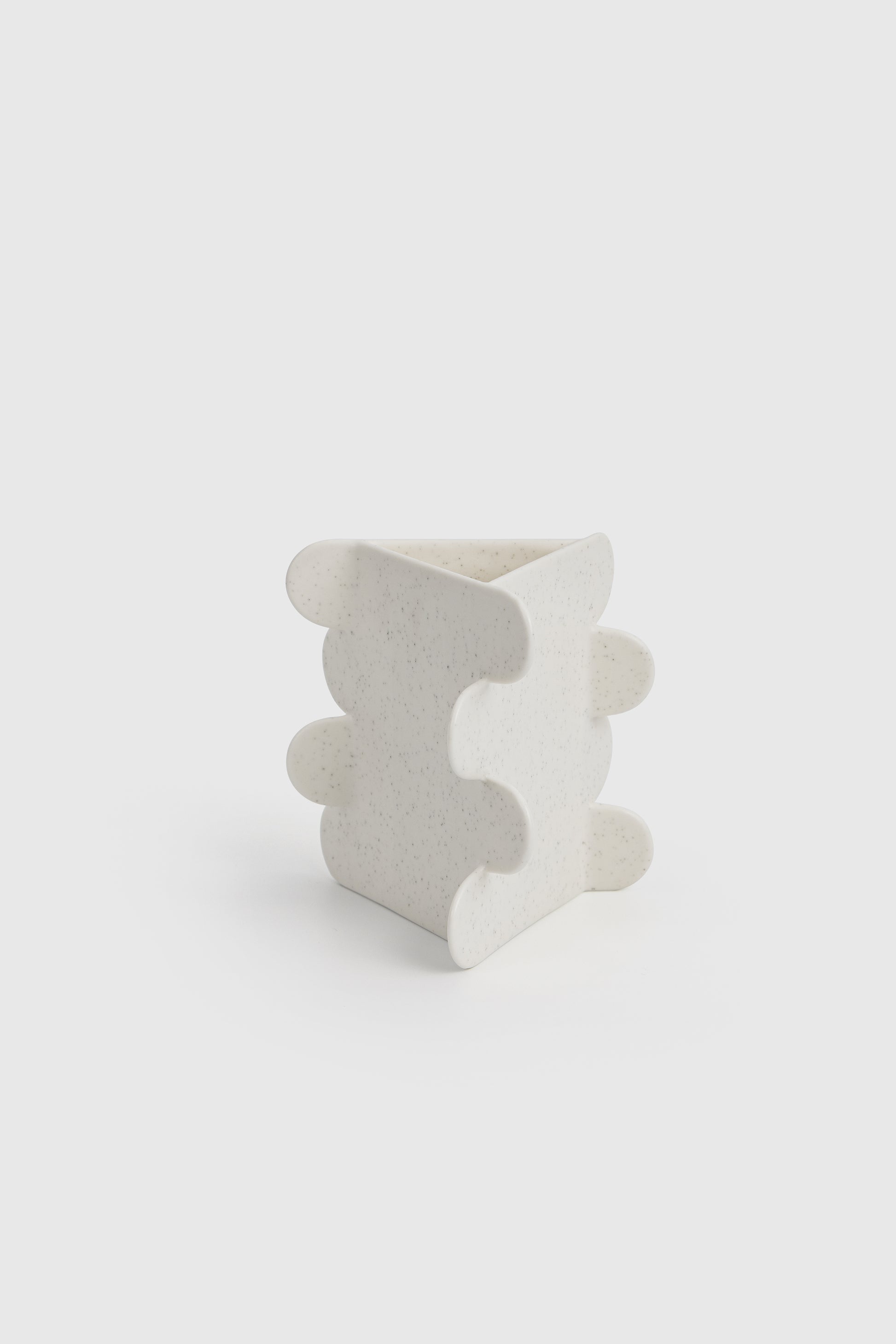 White ceramic vase with wavy design on a white background