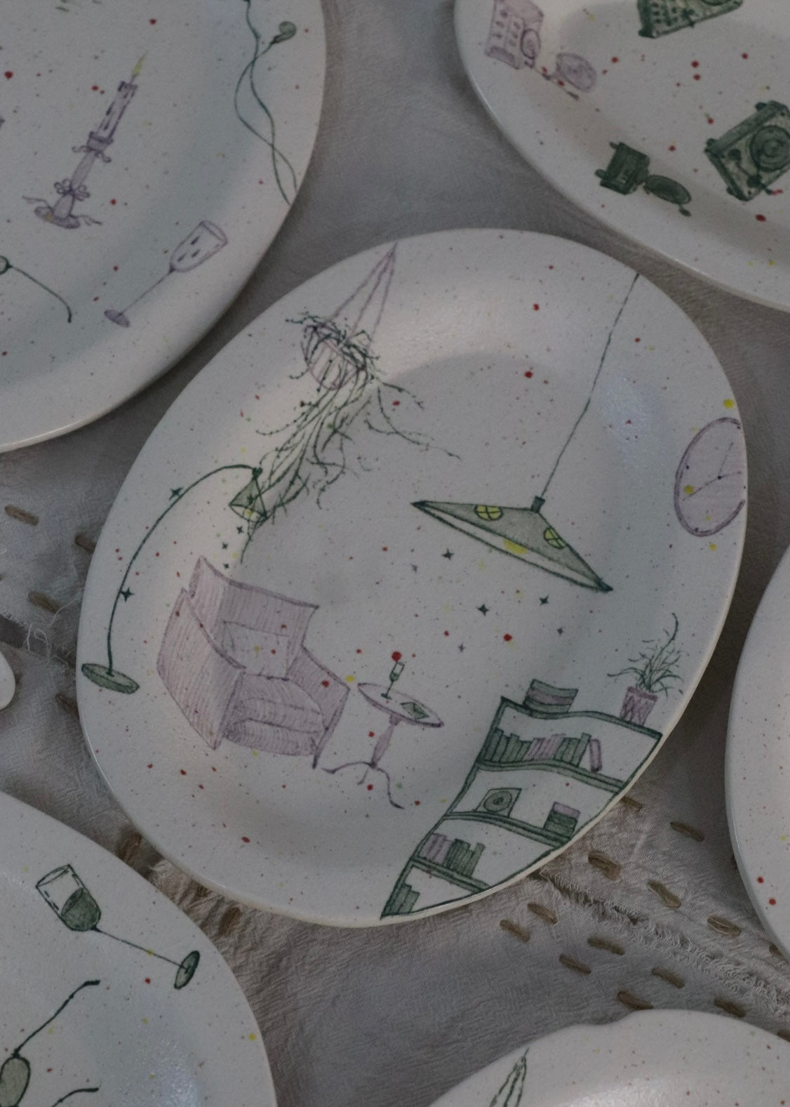 Set of ceramic plates with abstract drawings on a textured surface