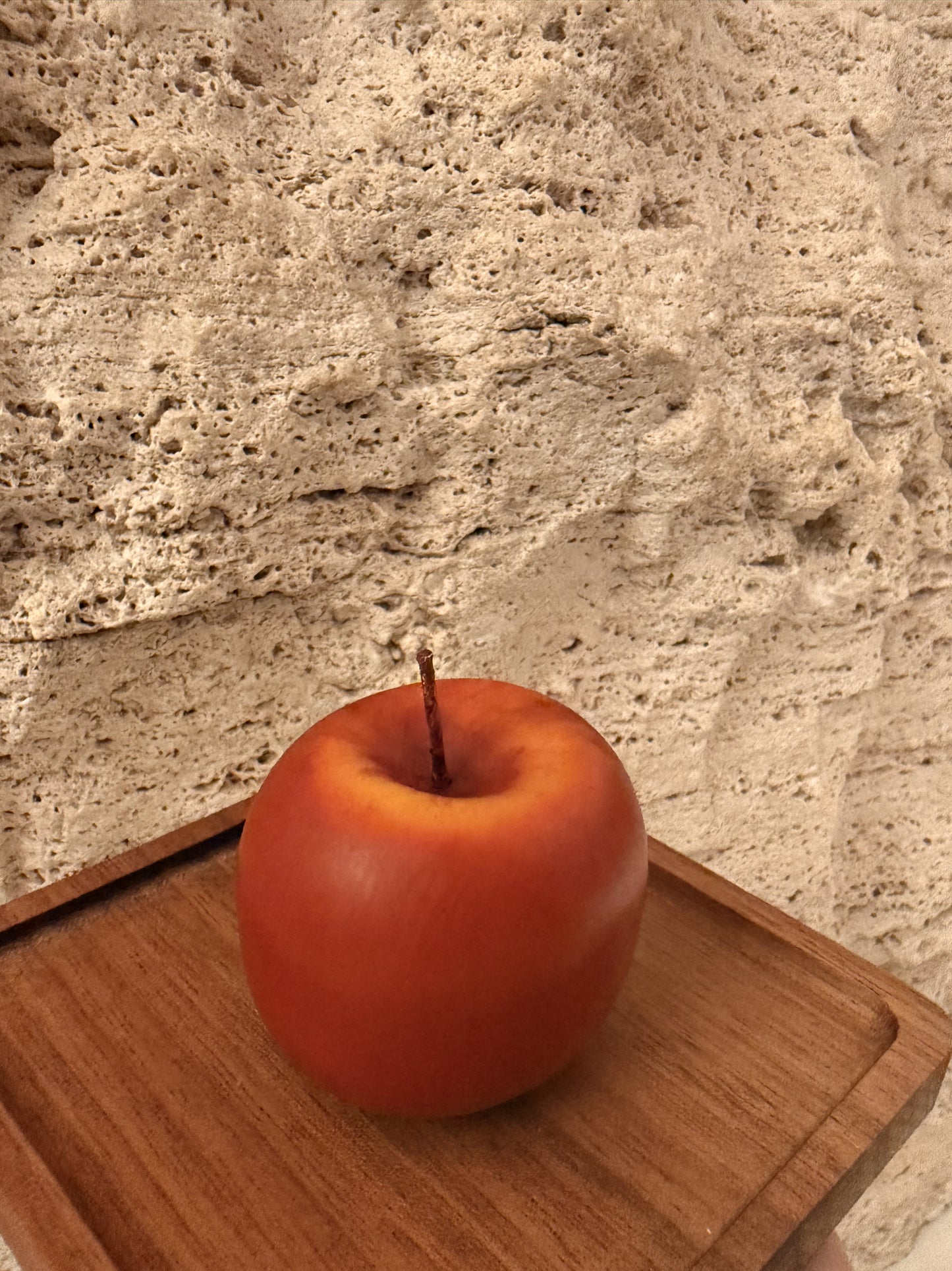 Red apple on a wooden cutting board with a stone countertop background