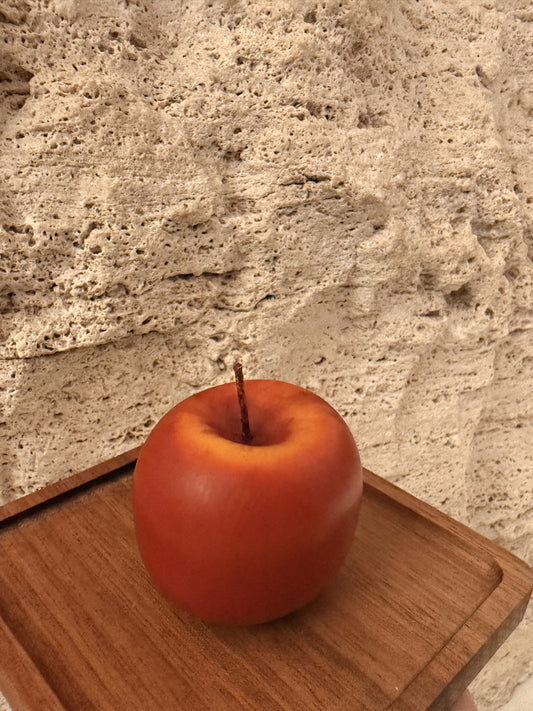 Red apple on a wooden cutting board with a stone countertop background