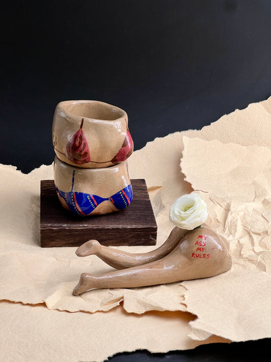 Ceramic shoes with a small rose on a textured surface