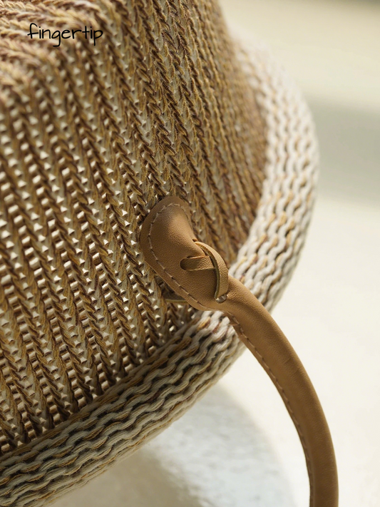 Close-up of a woven straw bag with a leather strap on a blurred background