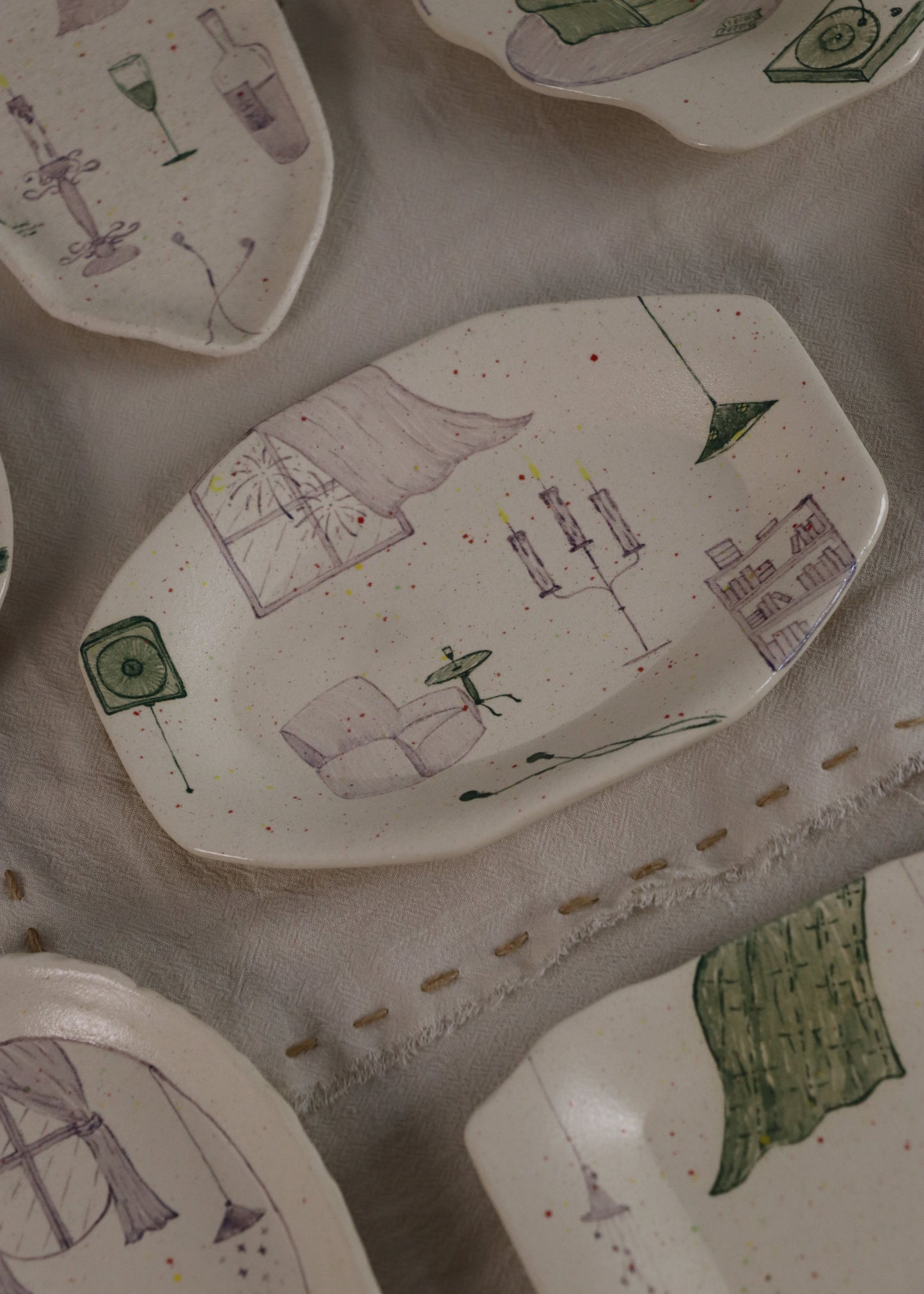 Collection of ceramic plates with various designs on a textured surface