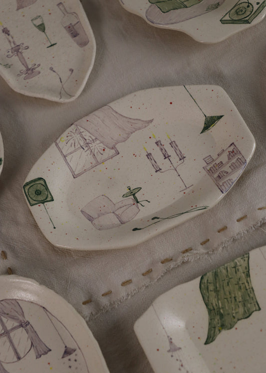 Collection of ceramic plates with various designs on a textured surface