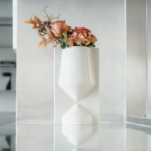 White geometric wall vase with flowers on a white wall