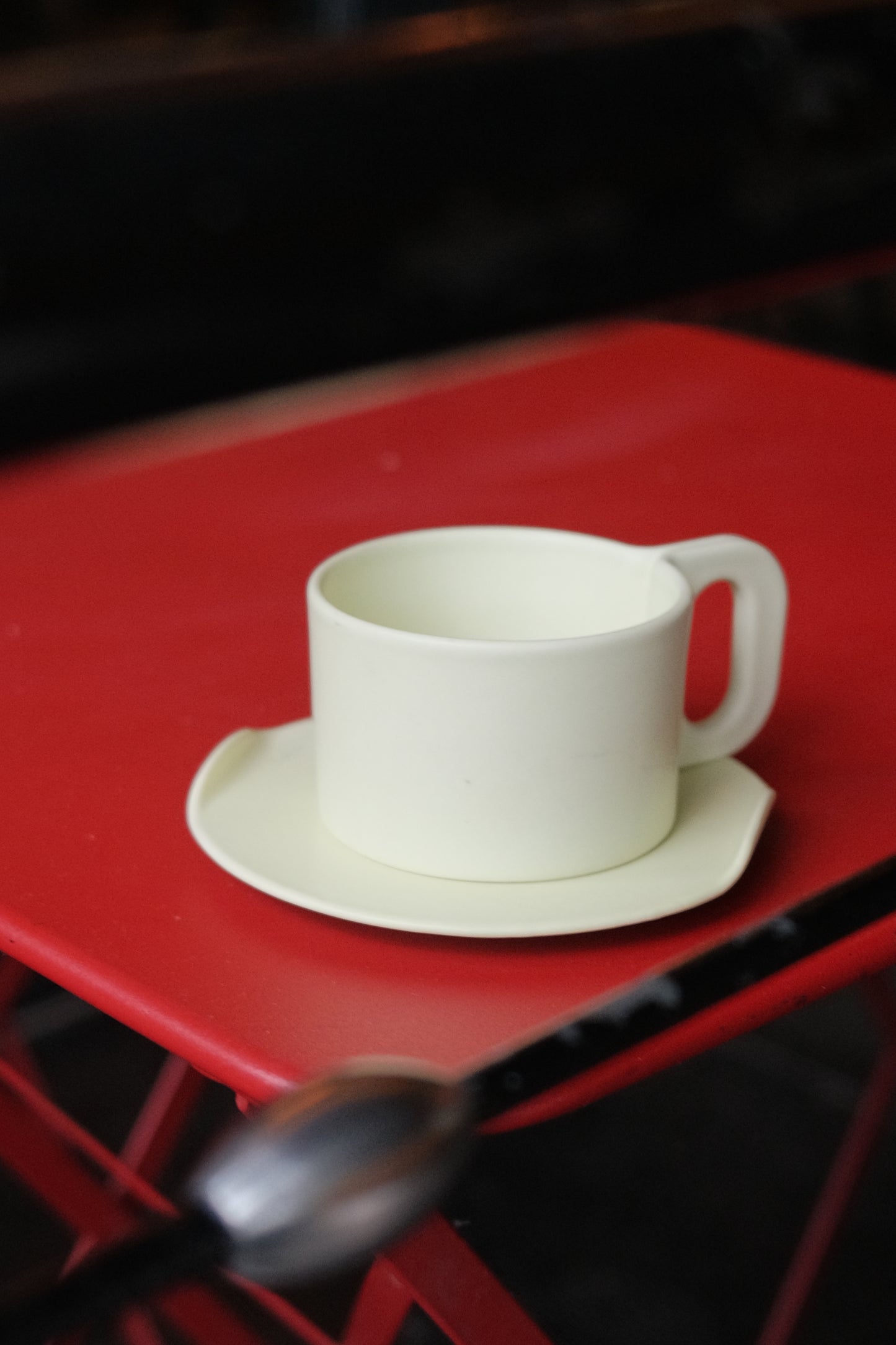 White ceramic cup with handle on a red background