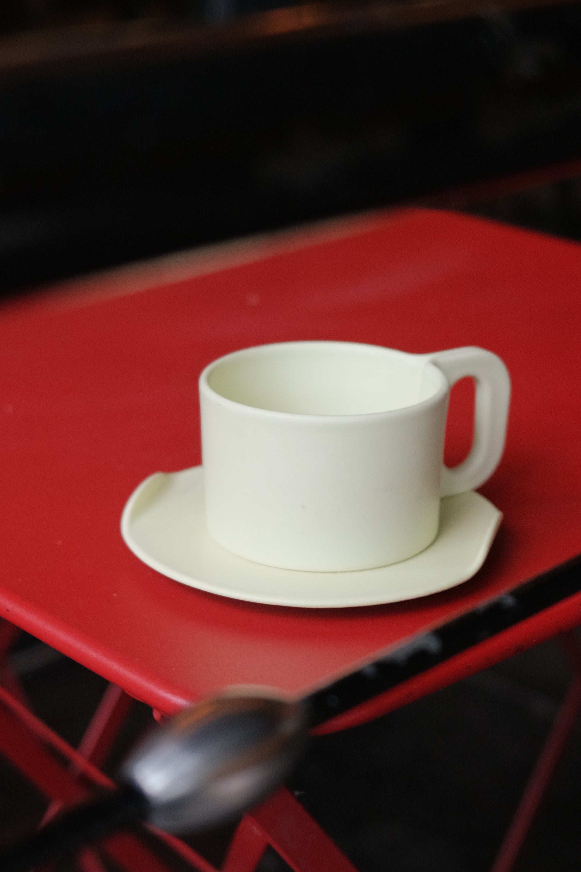 White ceramic cup with handle on a red background