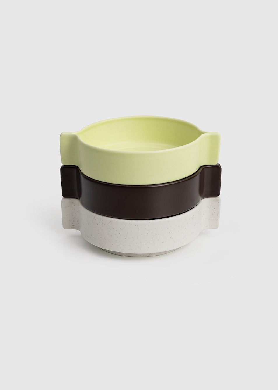 Modern ceramic mug with a light green top and black handle on a white background