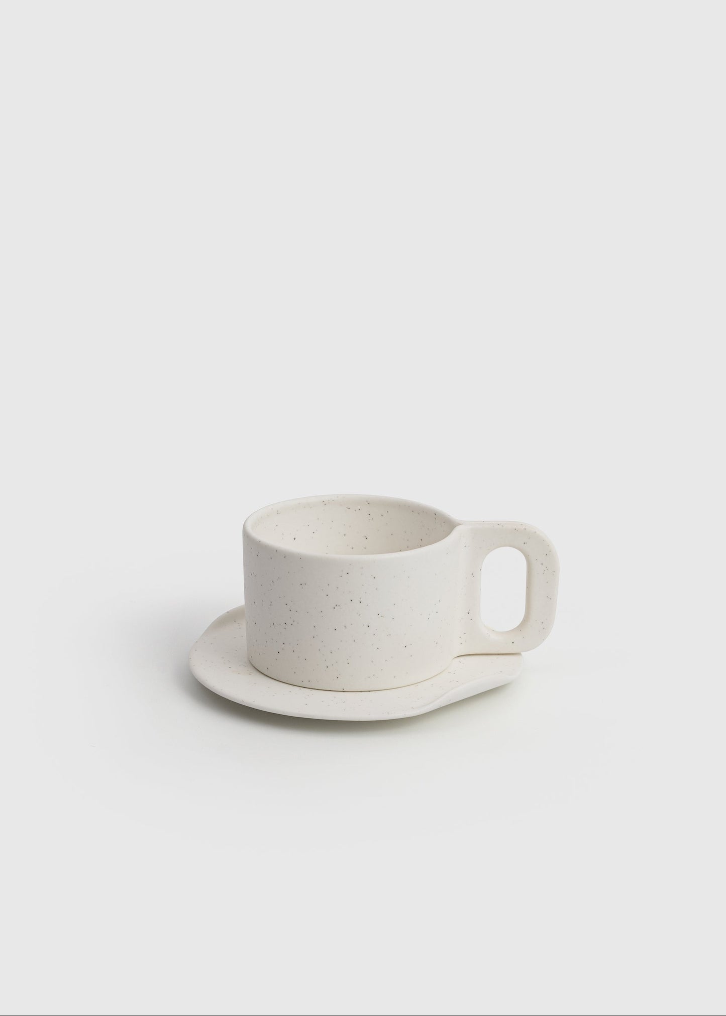 White ceramic cup and saucer on a light gray background