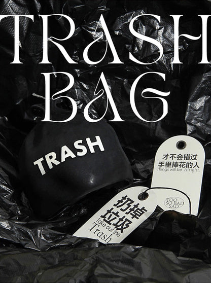Black trash bag with 'trash' label and Chinese text on a dark background
