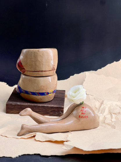 Ceramic containers with a white rose on a textured surface