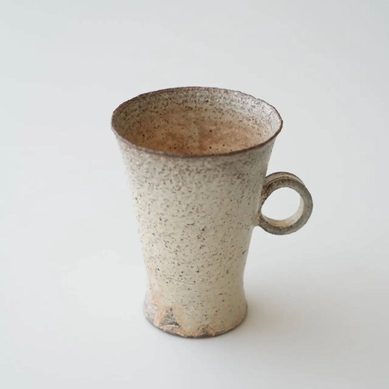 Speckled ceramic mug on a light gray background