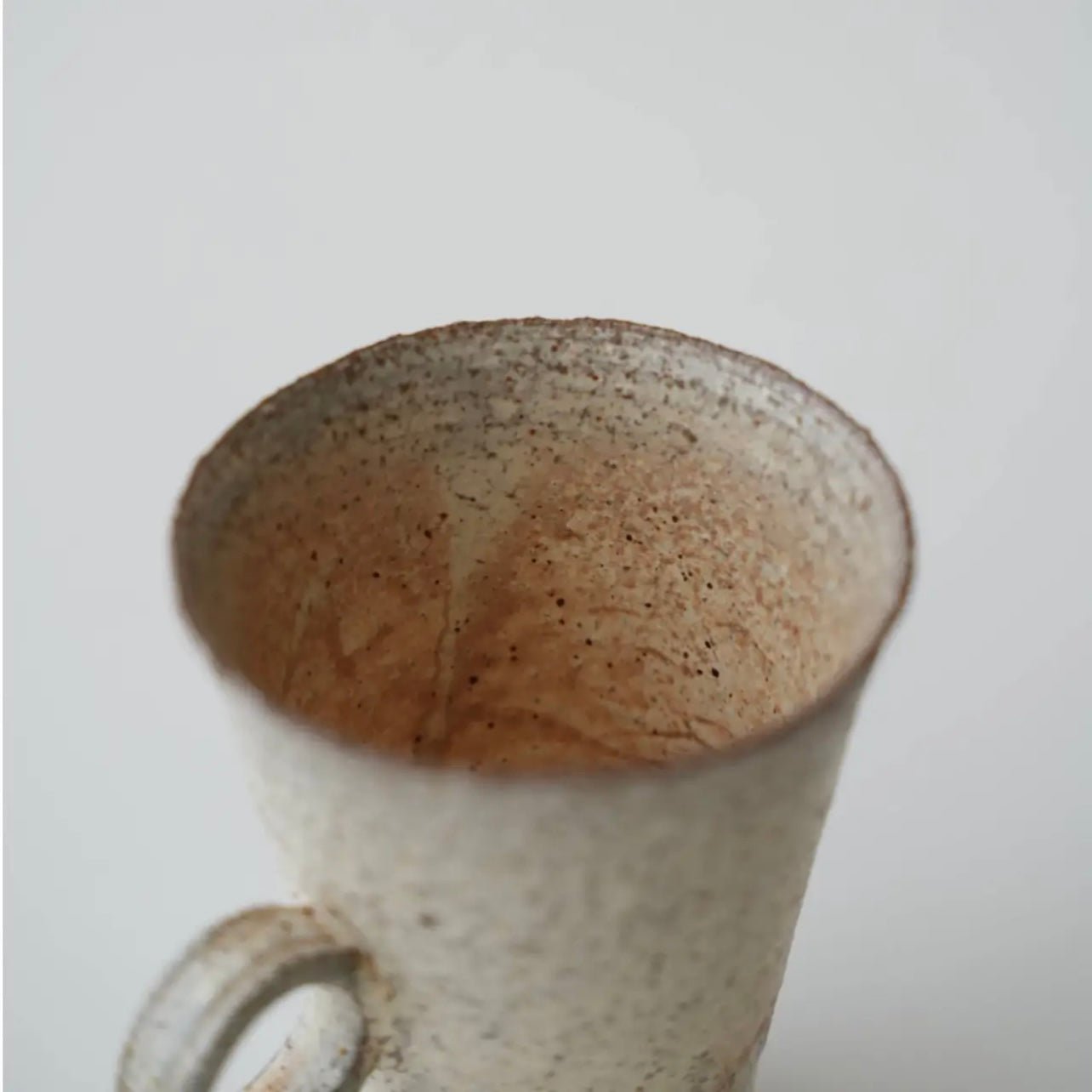 Speckled ceramic mug on a plain background