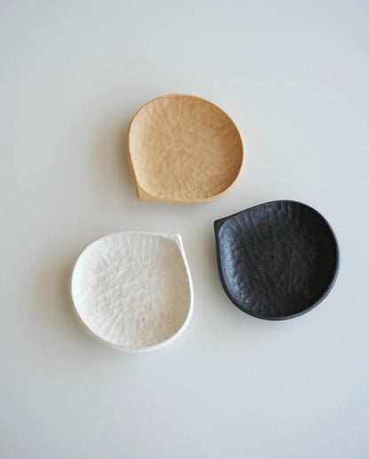 Three ceramic bowls in beige, white, and black on a light gray background with 'VAST' branding.