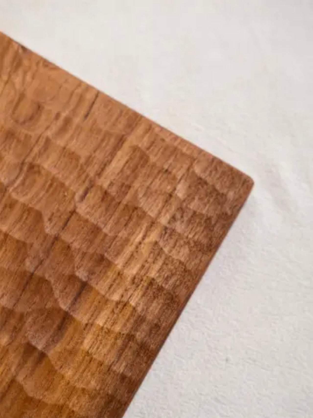 Close-up of a wooden cutting board on a white surface