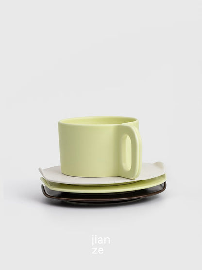 Green ceramic cup and saucer set on a light gray background with 'jian ze' branding.