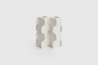 White ceramic vase with wavy pattern on a light gray background