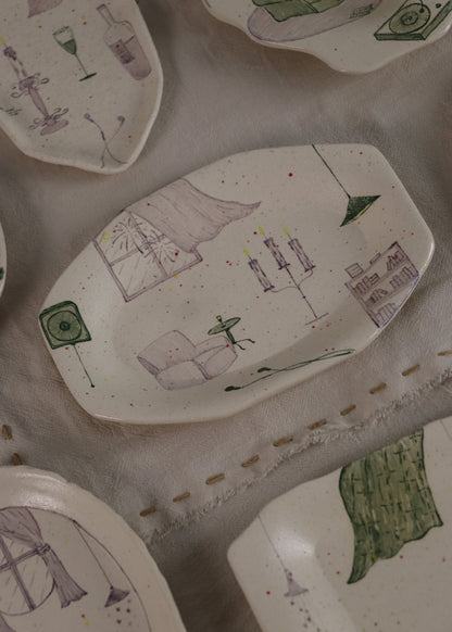 Collection of ceramic plates with various designs on a textured surface