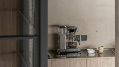Coffee machine on a kitchen counter with a neutral wall background