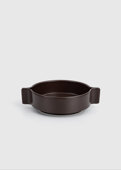 Dark brown ceramic dish with handles on a light gray background